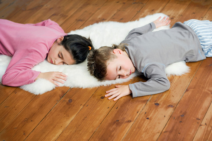 Bambini che dormono sul pavimento in Parquet